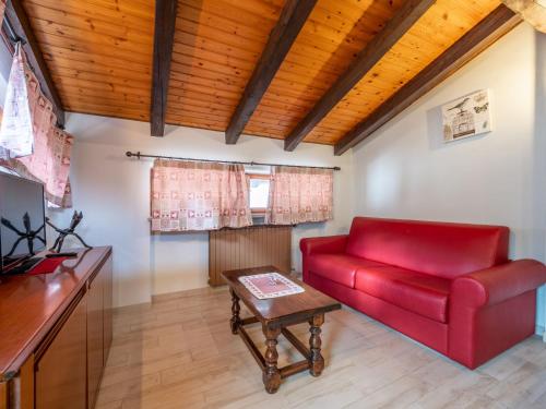 费尼斯Apartment Aux Oiseaux by Interhome的客厅配有红色的沙发和桌子