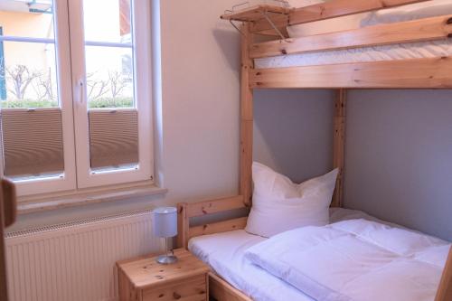 Groß KirrHaus Sabine - EG的一间卧室配有双层床和窗户。