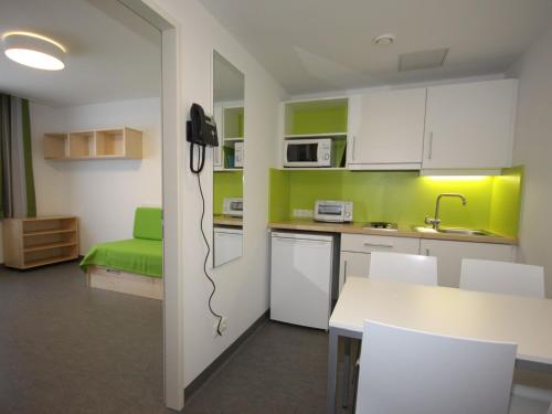 Sankt UlrichApartment smart living by Interhome的厨房配有白色橱柜和绿色墙壁