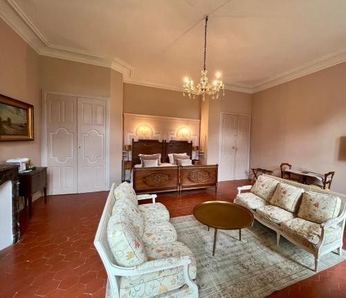 佩兹纳斯Château de Roquelune的客厅配有白色家具和吊灯。