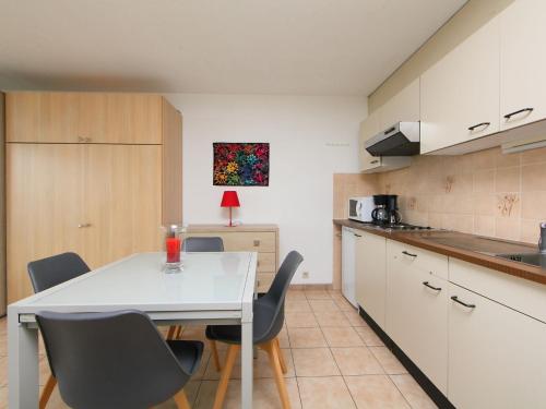 布列登Studio Residentie Astrid-9 by Interhome的厨房配有白色的桌椅