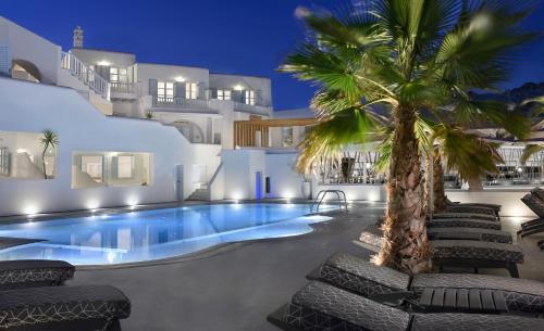 普拉迪斯亚罗斯佩蒂诺斯海滩酒店的一座房子前面的游泳池,上面有棕榈树