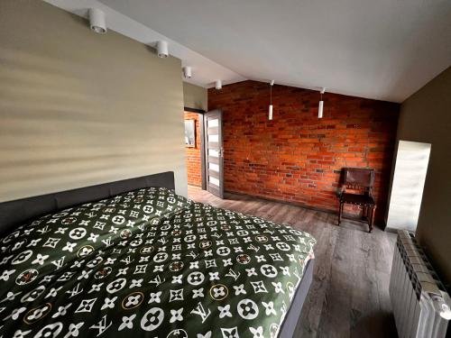 斯凯尔涅维采Apartamenty na 1 Maja的一间卧室设有一张床和砖墙