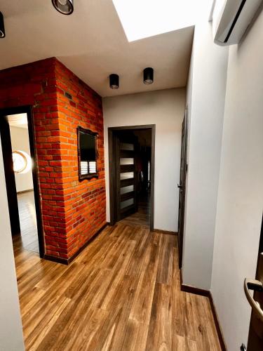 斯凯尔涅维采Apartamenty na 1 Maja的一间空房,设有砖墙和木地板