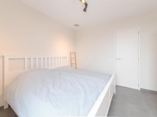 布列登Apartment Lakeside by Interhome的一间白色卧室,配有一张床和一个衣柜