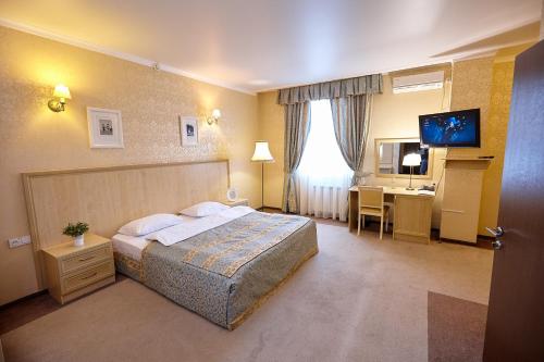 季马绍夫斯克泰塔酒店的配有一张床和一张书桌的酒店客房