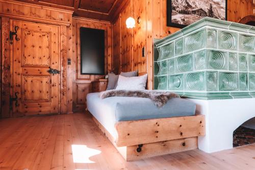 埃尔比格纳尔普Alpenherz Chalet的一间卧室配有一张带绿色玻璃床头板的床