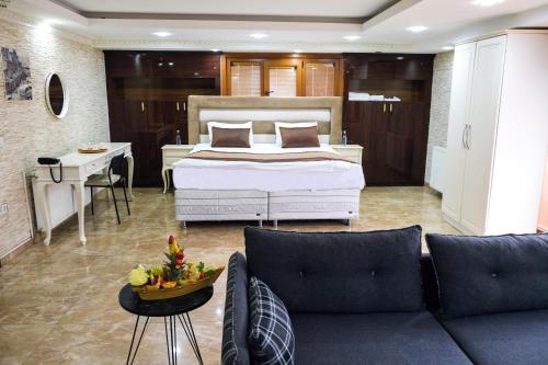 伊斯坦布尔Florya House Hotel的一间卧室配有一张床,客厅配有沙发