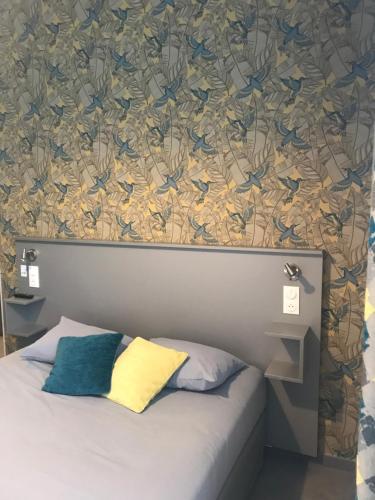 凯恩Smart Appart Caen République的一间卧室配有一张床铺,墙上贴着鸟儿壁纸