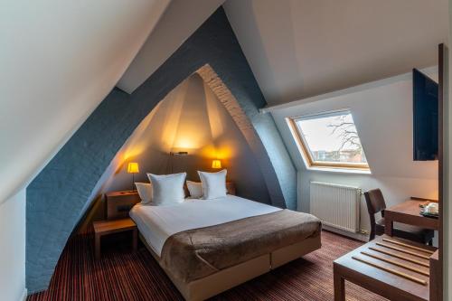 海斯特奥普登贝尔赫蒙特别墅酒店的阁楼上的卧室配有一张大床