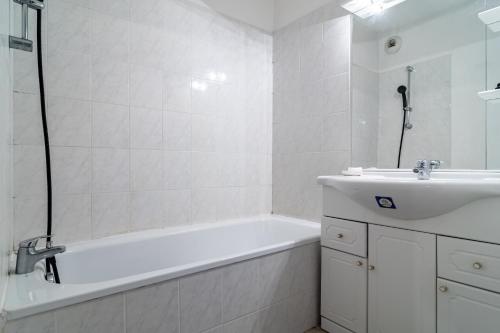 勒吕克Le Laury的白色的浴室设有浴缸和水槽。