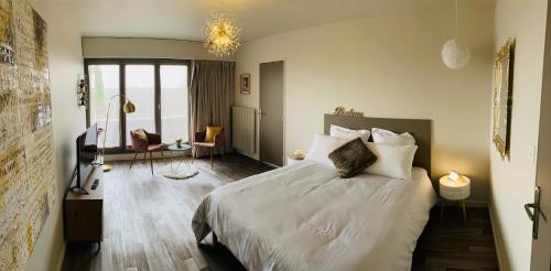 里摩日Cocon déco + terrasse & parking fermé Zénith Ester的卧室配有一张带白色床单和枕头的大床。