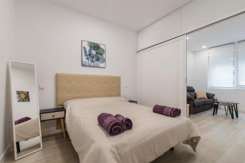 马德里4Torres Homes - Carmen的一间卧室配有一张大床,上面有紫色枕头