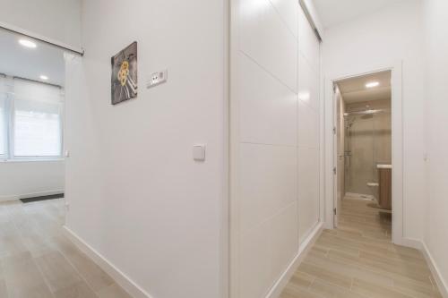 马德里4Torres Homes - Carmen的一条带白色墙壁和玻璃门的走廊