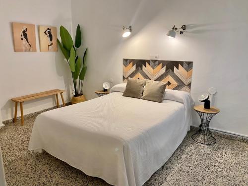 马贝拉Hostal Paco Marbella的卧室配有一张白色的大床和两张桌子