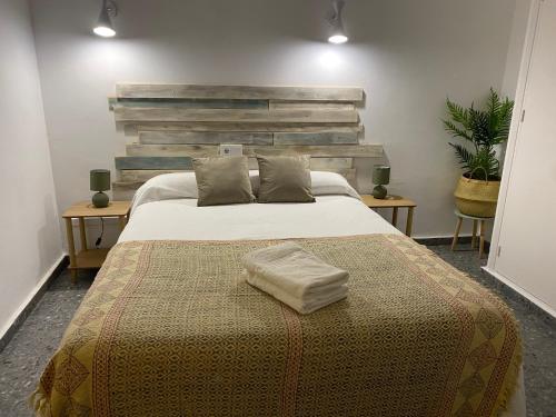 马贝拉Hostal Paco Marbella的一间卧室配有一张大床和木制床头板