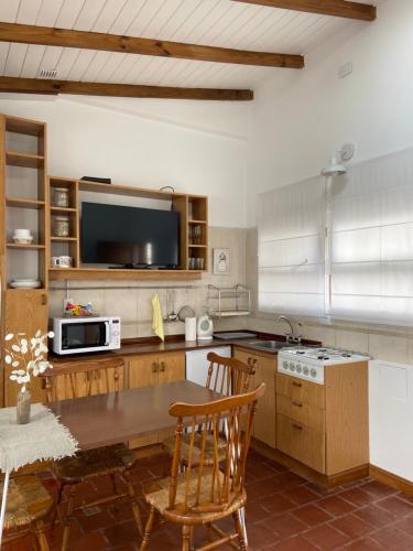 马德普拉塔Espacio C的厨房配有木桌和电视。