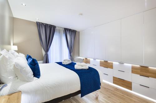 尚蒂伊Suite Appart Place Versepuy的一间卧室配有一张带蓝白色枕头的大床