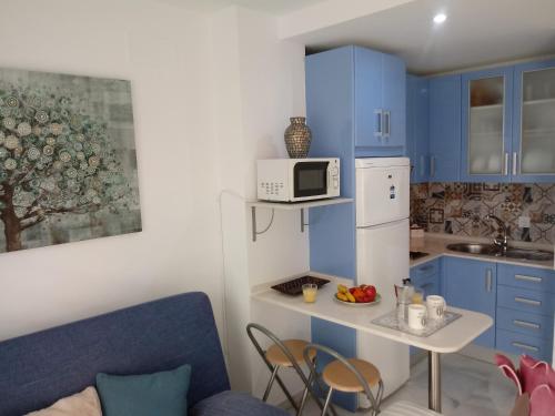 罗塔Apartamento Rotasol的一间小厨房,内配蓝色橱柜和微波炉