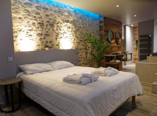 贝桑松LA DOLCEVITA SPA Chambre privative的一间卧室配有带毛巾的床