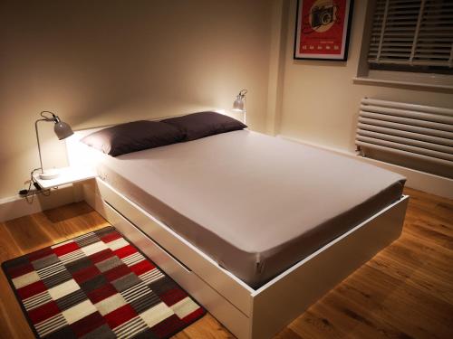 伦敦LUXE HILL GETAWAY的卧室内的一张床位,配有地毯和灯