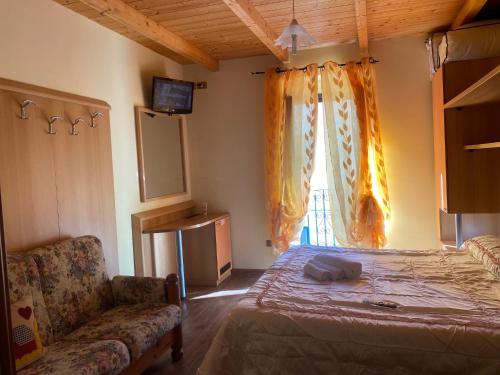 卡拉马尼科泰尔梅La casetta della nonna的一间卧室配有一张床、一张沙发和一个窗口