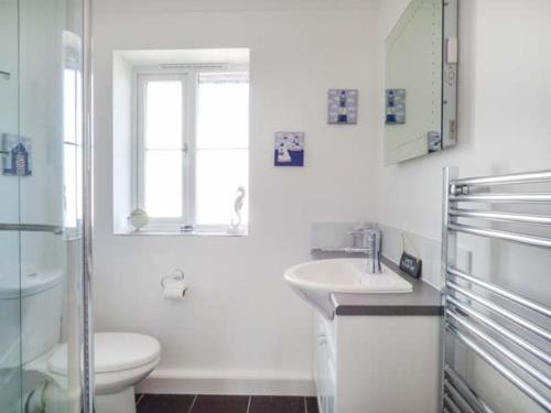 圣梅尔林7 Harlyn Cottages的白色的浴室设有卫生间和水槽。