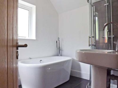 多尔盖罗Llechwedd的白色的浴室设有浴缸和水槽。