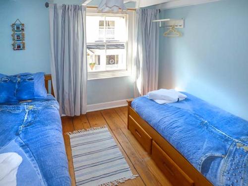 斯泰兹Broomhill View的一间卧室设有两张床和窗户。