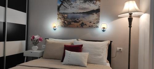 乌尔齐尼Guest House AGA的一间卧室配有带枕头的床铺和绘画