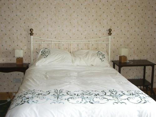 DrumlembleHomestone Farm的卧室配有白色的床和两张桌子