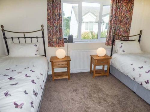 HorrabridgeMoorside的一间卧室设有两张床和两张带台灯的桌子。
