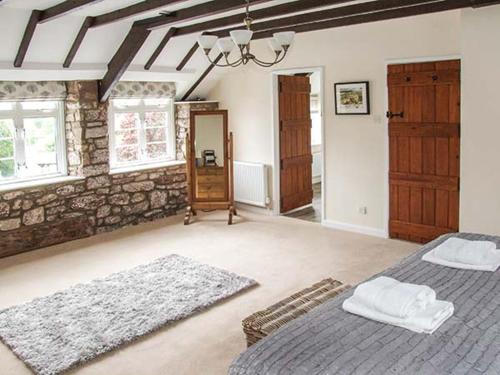 惠特彻奇Ganarew Cottage的一间卧室设有两张床和石墙