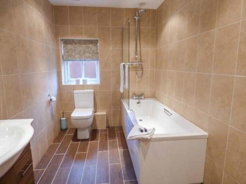 沃尔沃思Walworth Castle Holiday Cottage的浴室配有卫生间、浴缸和水槽。