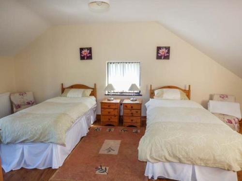 LlanddulasYsgubor - Barn的一间卧室设有两张床和窗户。