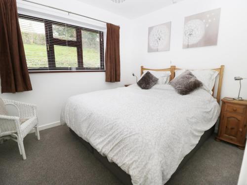 Buckland St MaryFlintstones的卧室配有白色的床和窗户。