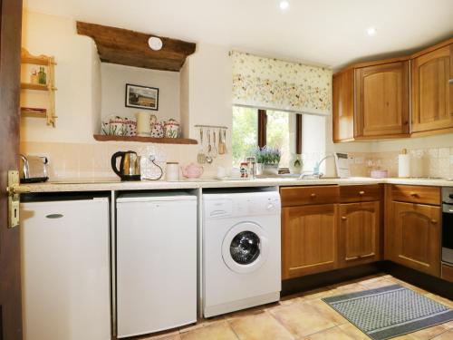MorlandRosegarth Cottage的厨房配有洗衣机和烘干机