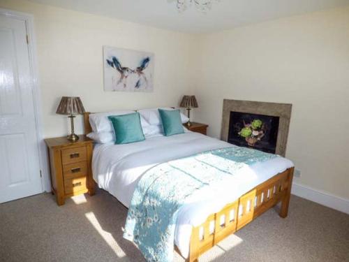 WolsinghamMill Cottage的一间卧室配有一张带蓝色枕头的大床