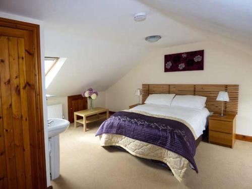 兰卡斯特Poppy Cottage的一间卧室设有一张大床和一个水槽