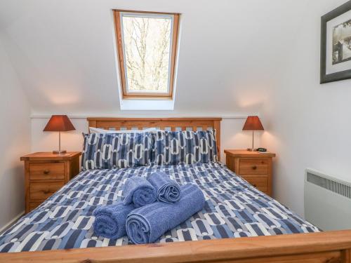 BroughtonThe Roost的一间卧室配有一张带蓝色毛巾的床
