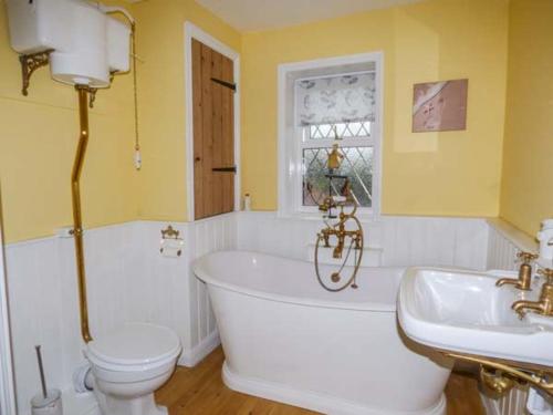 赫彻姆Fern Cottage的带浴缸、卫生间和盥洗盆的浴室