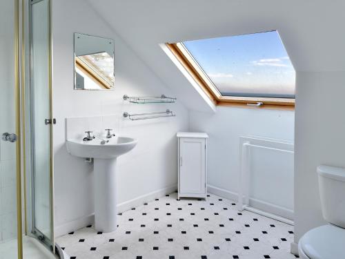 Gorran HavenTreverrion的一间带水槽和卫生间的浴室以及窗户。