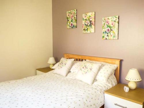 斯泰夫利North Lodge的卧室配有一张墙上三幅画作的床