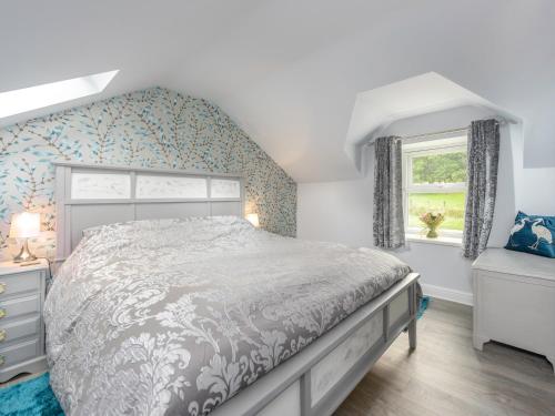 阿尼克Rose Cottage的一间卧室设有一张大床和一个窗户。