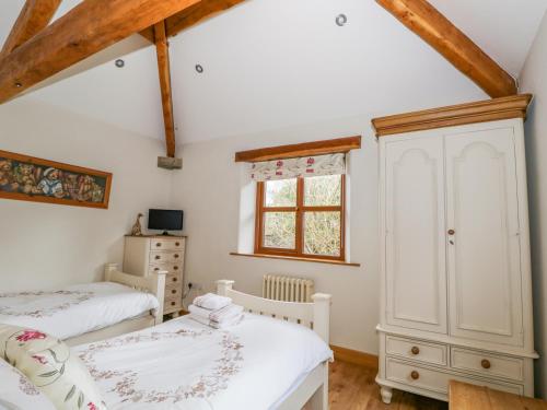 SedgwickHawthorn Cottage的一间卧室设有两张单人床和一个窗户。