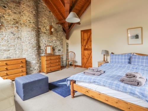 LuppittSwallows Cottage的一间卧室设有一张床和石墙