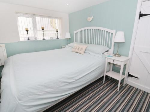 本莱赫The Hideaway的卧室配有白色的床和白色床头柜。