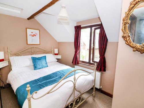 拉尼德洛伊斯Beech Cottage的一间卧室配有一张床和镜子