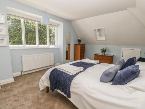 斯卡伯勒Green Tor的卧室配有带蓝色枕头的大型白色床