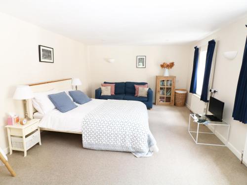 利德尼The Granary的一间卧室配有一张床和一张蓝色的沙发